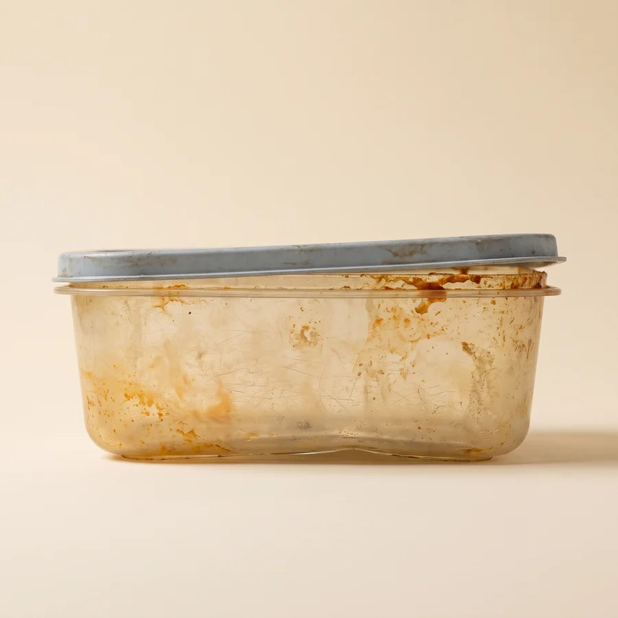 A stained, worn plastic food container